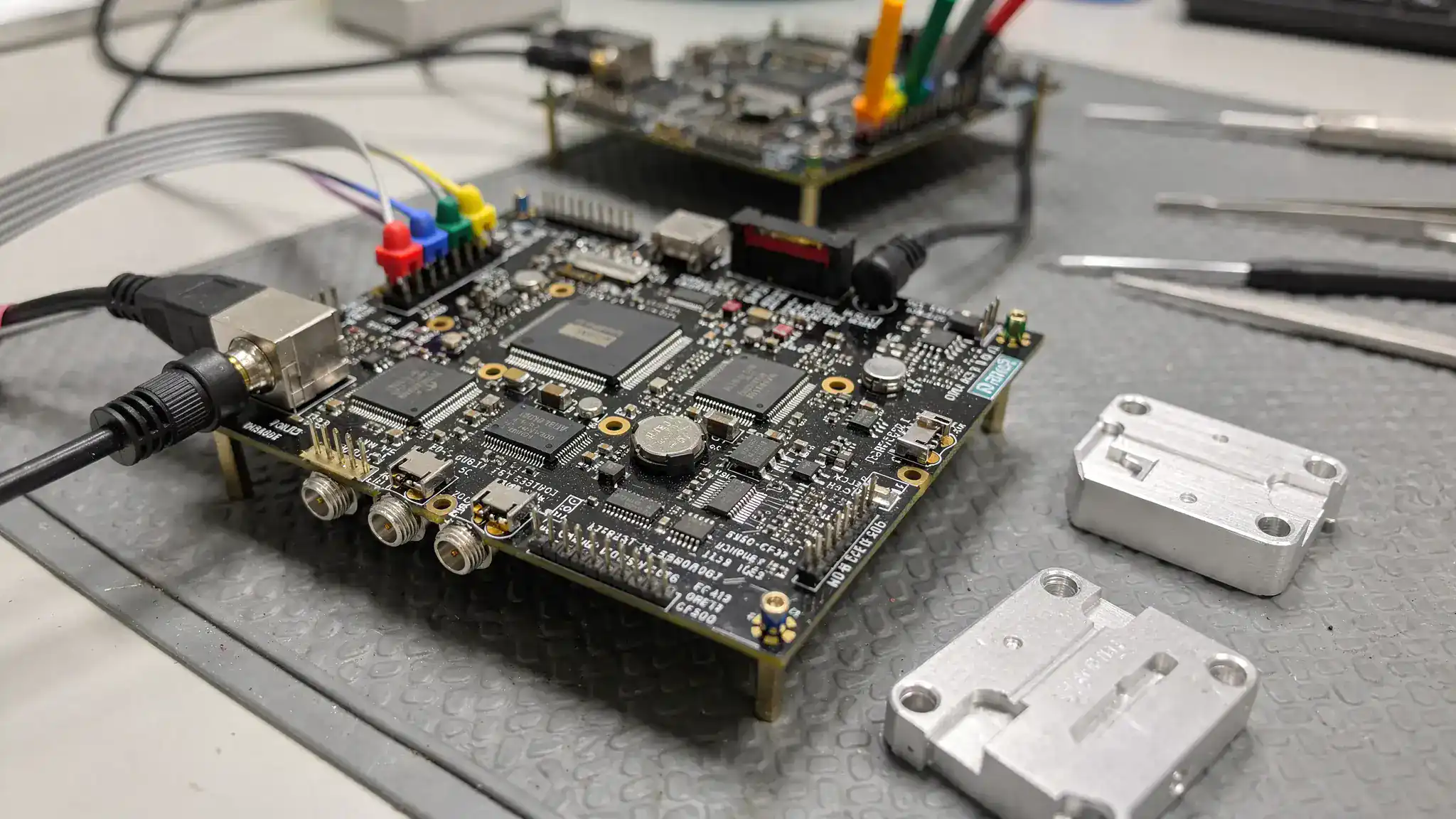 Production-ready PCBA documentation, test equipment and assembled electronics on an engineering bench